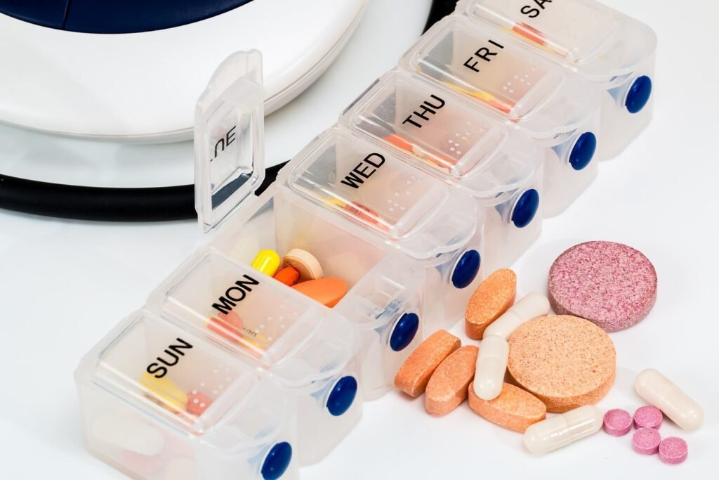 Kotak obat mingguan berisi tablet dan kapsul vitamin, contoh obat dan suplemen yang perlu disebutkan sebelum cek lab