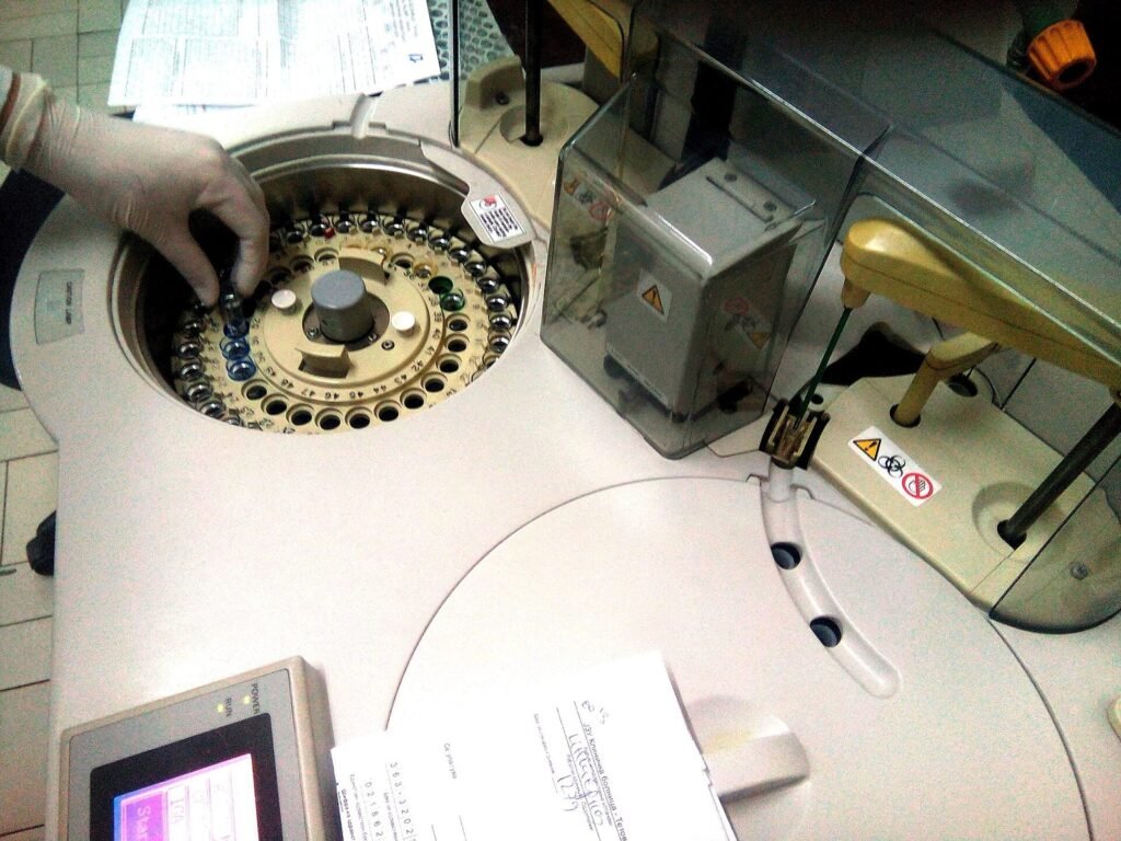 Petugas laboratorium memasukkan sampel darah ke alat analisis otomatis untuk pemeriksaan imunologi