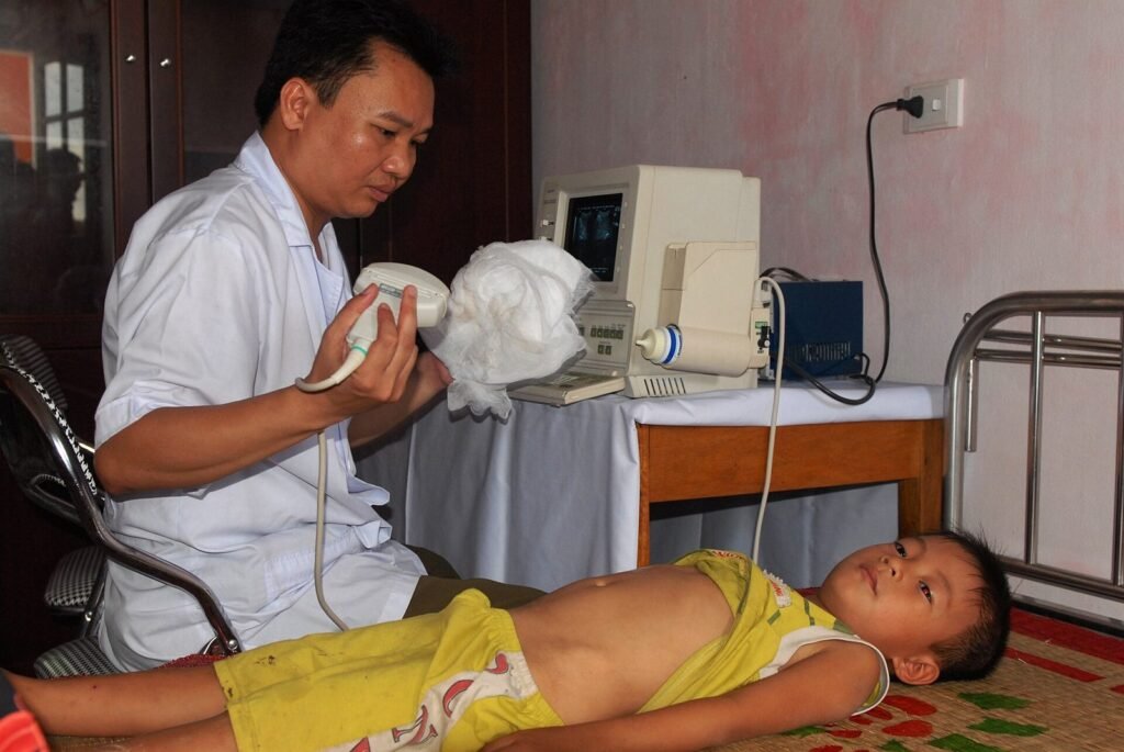 Dokter memeriksa perut seorang anak dengan alat USG